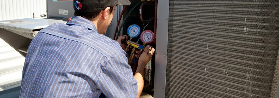 HVAC technician servicing a condenser unit in Delray Beach